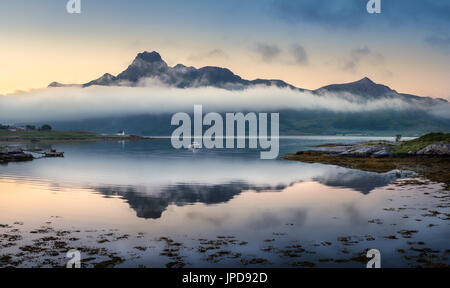 Paesaggio panoramico con la riflessione di montagna e nuvole basse a notte estiva in Lofoten, Norvegia Foto Stock