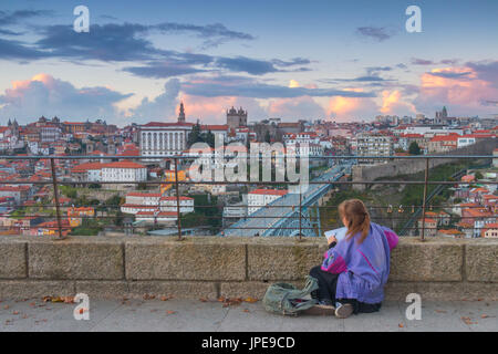 Una donna di disegno al tramonto nel porto. La città di Oporto, Distretto di Porto, Portogallo, Europa Foto Stock