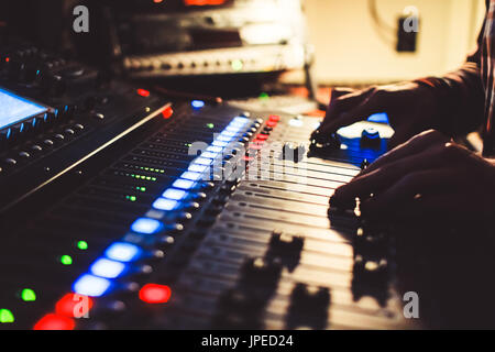 Le mani del tecnico del suono sulla console di miscelazione Foto Stock