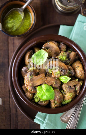 Funghi saltati con pesto e di foglie di basilico fresco. Vista aerea Foto Stock