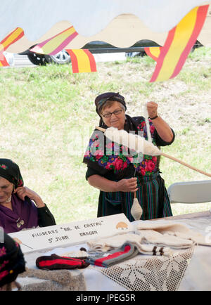 La donna gira la lana al mercato di domenica a Arreau, Hautes-Pyrénées, Francia. Foto Stock