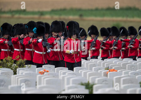 Le truppe britanniche di prendere parte alla commemorazione di eventi per la Prima Guerra Mondiale La Battaglia di Passchendaele a Tyne Cot cimitero vicino Ypres in Belgio. Il primo battaglione delle guardie irlandesi marzo attraverso la tomba di pietre Foto Stock