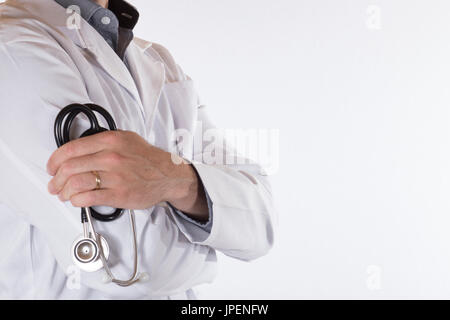 Medico tenendo un stetoscopio avvolto nella sua mano come si sta con bracci ripiegati in un vicino la vista laterale isolato su bianco con spazio di copia Foto Stock