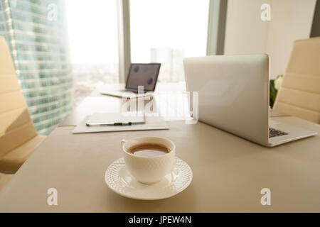 Ufficio moderno workplace, tazza di caffè, portatili su negot conferenza Foto Stock