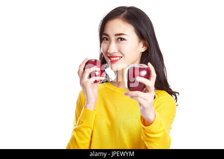 Giovane e bella donna asiatica che mostra due mele rosse, isolato su sfondo bianco. Foto Stock