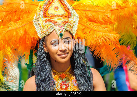 Interprete femminile che indossa un costume colorato e copricapo in sfilata per le strade di Edimburgo nel carnevale del Jazz e Blues Festival Foto Stock