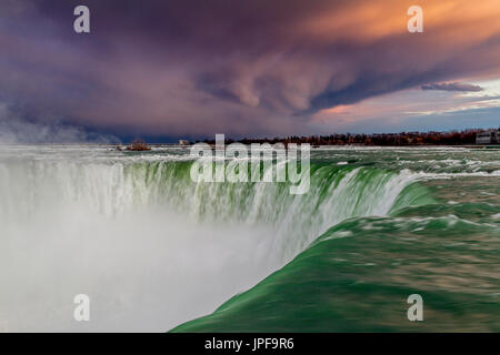 Le fragorose cortina d'acqua si riversano sulle cascate Horseshoe delle Cascate del Niagara, Ontario, Canada, mentre in lontananza si accumula un cielo minaccioso Foto Stock