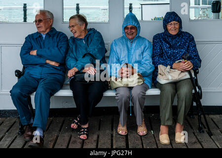 Brighton, Regno Unito. 2 agosto, 2017. Regno Unito Meteo. Un gruppo di pensionati si ripara dalla pioggia sul molo di Brighton, Brighton East Sussex, Regno Unito. Credito: Concedere Rooney/Alamy Live News Foto Stock