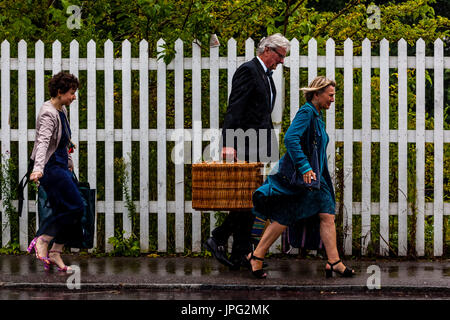 Lewes, Regno Unito. 2 agosto, 2017. Regno Unito Meteo. Appassionati di Opera arriva a Lewes stazione ferroviaria sotto la pioggia en route al Teatro dell'opera Glyndebourne per una performance di Don Pasquale, Lewes, East Sussex, Regno Unito. Credito: Concedere Rooney/Alamy Live News Foto Stock