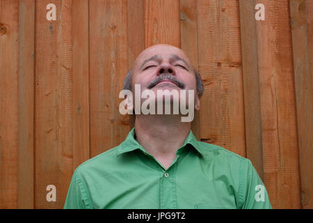 Bel uomo maturo è guardando verso l'alto e sorridente Foto Stock