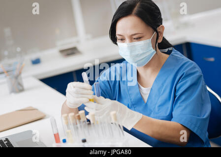 Laboratorio professionale lavorando indossare una mascherina chirurgica Foto Stock
