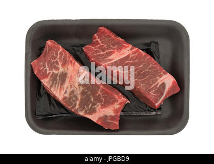 Vista dall'alto di due materie carni bovine disossate le nervature brevi in una schiuma nera butcher vassoio isolato su uno sfondo bianco. Foto Stock