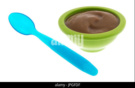 A che serve di pere e blackberry purea organico cibo per neonati in una ciotola verde con un cucchiaio di blu al lato isolato su uno sfondo bianco. Foto Stock