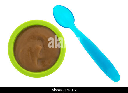 Vista dall'alto di una porzione di pere e blackberry purea organico cibo per neonati in una ciotola verde con un cucchiaio di blu al lato isolato su uno sfondo bianco. Foto Stock