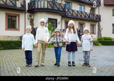 Cute ragazze e ragazzi in maglieria di trascorrere del tempo dalla loro scuola Foto Stock