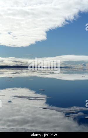 Glassy mare calmo della baia di Baffin nel circolo polare artico dando una bella riflessione di cielo, visto da un expedition nave Foto Stock