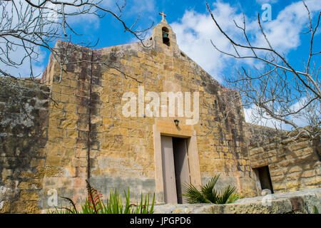 Saint George's cappella, una cappella medievale in buone condizioni e oggi utilizzato, a Birzebugga su un nuvoloso ma bella giornata invernale, porta leggermente socchiusa, Malta Foto Stock