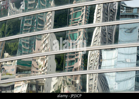 Grattacieli si riflette nelle finestre di highrise edificio creando interessanti modelli distorti Foto Stock