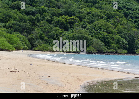 Bel pomeriggio in spiaggia con sabbia bianca e la fitta vegetazione verde nella parte posteriore Foto Stock