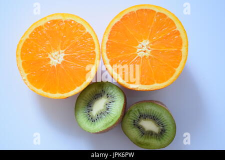 Una grande arancione e un kiwi tagliati a fette metà Foto Stock