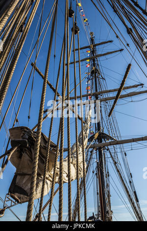 Parte nautico di una barca o un grande vecchio veliero con cordicelle, rigging, vela, piloni, nodi, segnale bandiere blu cielo Foto Stock