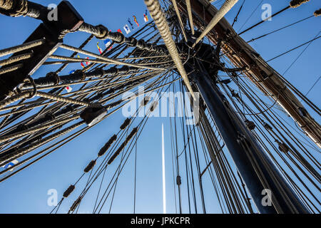 Parte nautico di una barca o un grande vecchio veliero con cordicelle, rigging, vela, piloni, nodi, segnale bandiere blu cielo Foto Stock