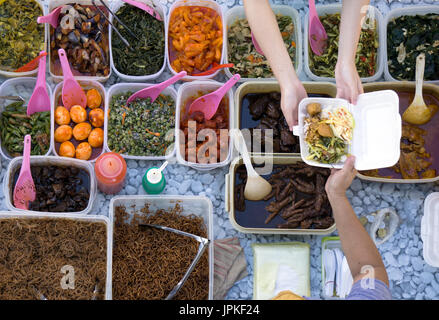 Vista superiore del fornitore non identificato e il cliente presso il cibo stallo nella città di Kota Kinabalu mercato alimentare. Foto Stock