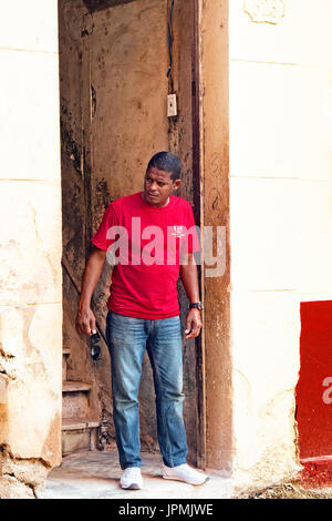 Un uomo cubano sorge in un aperto porta a l'Avana, Cuba, Foto Stock