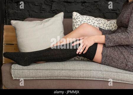 Femmina mettendo su calze nere Foto Stock