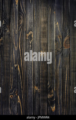 Legno scuro dello sfondo. Pannello di legno verticali di età compresa tra le schede madri con spot di luce Foto Stock