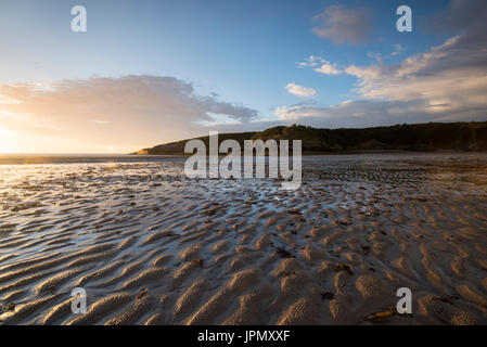 Tramonto sulla spiaggia con la bassa marea a Cemaes Bay, Anglesey Wales UK Foto Stock