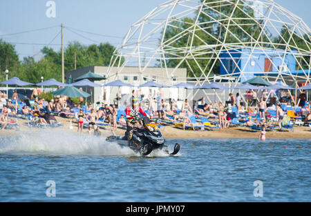 Uomo in motoslitta va veloce sull'acqua in estate Foto Stock