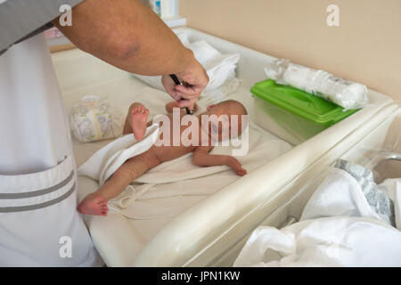 Medico esplorando il bambino nella culla Foto Stock