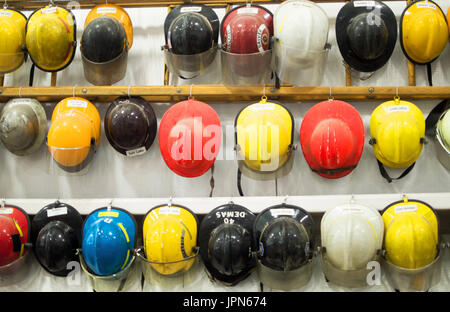 Una fila di firefighter caschi in esposizione al museo dei vigili del fuoco. Foto Stock