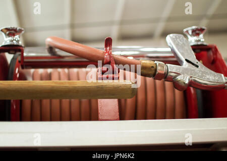 Un tubo flessibile di vigili del fuoco bobina sul retro di un'annata camion dei pompieri sul visualizzatore in corrispondenza di un museo dei vigili del fuoco. Foto Stock