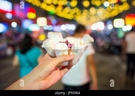 Femmina presentando un tailandese gelato rotoli nel mercato alimentare Foto Stock