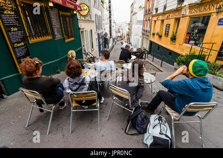 Tourist avente un aperitivo al Autour du Moulin ristorante e che ingiunge la vista delle strade di Montmartre e Parigi dalla cima della collina Foto Stock