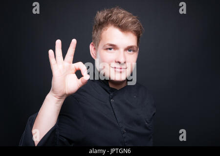 Fiducioso chef maschio che mostra il gesto ok Foto Stock