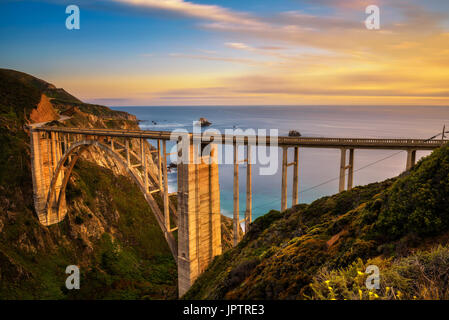 Bixby Bridge (Rocky Creek Bridge) e Pacific Coast Highway al tramonto vicino a Big Sur in California, Stati Uniti d'America. Lunga esposizione. Foto Stock