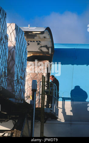 Carico che viene caricato da un uomo su un basso-caricatore su un Korean Air Lines Boeing 747-200F Foto Stock