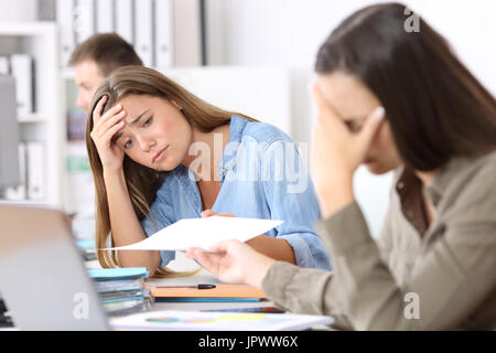 Ritratto di due dipendenti preoccupati ricezione cattiva notizia in un documento di Office Foto Stock