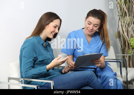 L'infermiera spiegando procedura medica ad un paziente in una sala di attesa Foto Stock