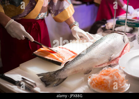 Chef per affettare il salmone fresco per il sashimi Foto Stock