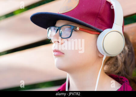 Ragazza carina l'ascolto di musica con cuffie per esterni Foto Stock