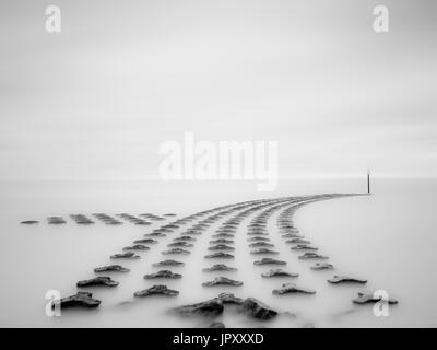 Una lunga esposizione immagine del mare difese a Felixstowe. Foto Stock