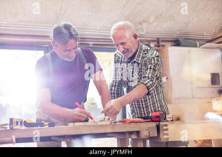 Falegnami maschio la marcatura e la misurazione di legno in officina Foto Stock