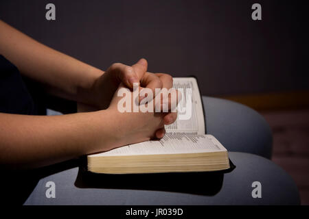 Ragazza giovane pregare e leggere Scritpure Foto Stock