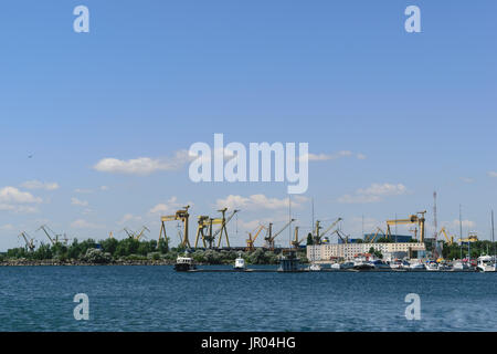 Mangalia, Constanta, Romania - Luglio 7, 2017: barca ancorata al Mangalia porto civile in Romania. Sullo sfondo vi sono l'industria pesante mar Foto Stock