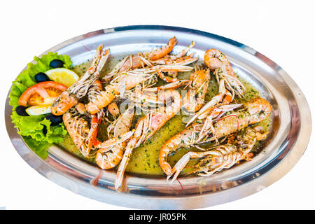 Cuocere gli scampi gamberi Gamberi in salsa al vino bianco con aglio e prezzemolo, closeup, isolato Foto Stock