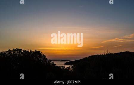 La prima luce appena prima di un favoloso orange sunrise sulla Sardegna, Italia Foto Stock